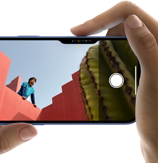 Ovládanie kamery na iPhone 16, pravý prst sa posúva po bočnej strane telefónu, aby upravil nastavenia kamery