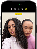 iPhone 18 Pro v čiernej farbe, pohľad spredu, na displeji vidno dvoch ľudí pózujúcich pred kamerou na ukážku prednej kamery Center Stage