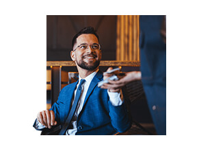 muž v obleku platiaci kartou