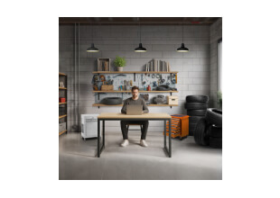 muž pracuje na notebooku v dielni