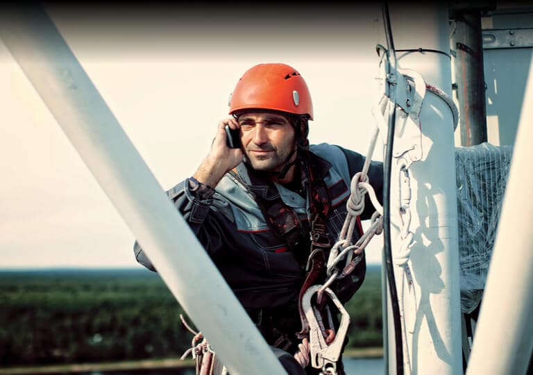 technik telefonujúci na vysielacej veži