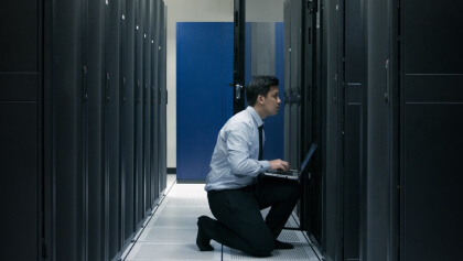 človek s notebookom v serverovni