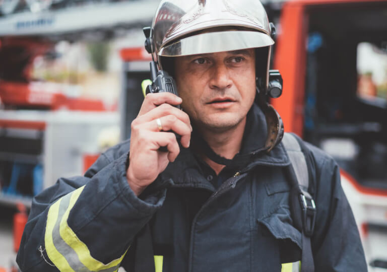 príslušník hasičského zboru hovoriaci do vysielačky