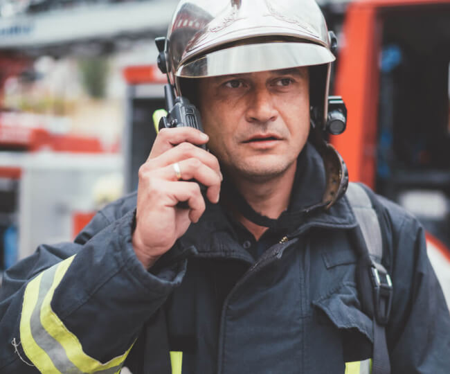 príslušník hasičského zboru hovoriaci do vysielačky
