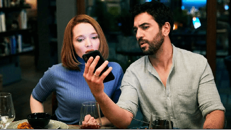 muž so ženou pozerajú do telefónu
