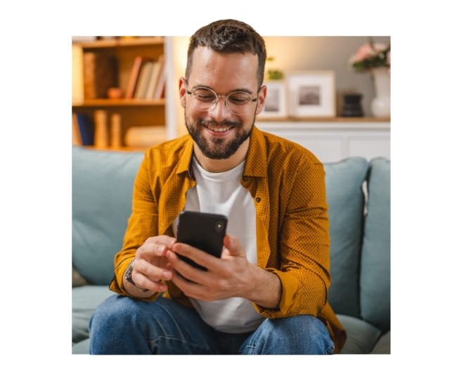 muž so smartfónom na gauči